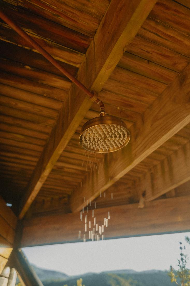 Brass outdoor shower under the timber roof
